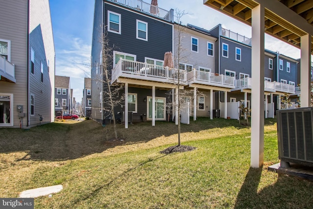 back of property featuring central air condition unit, a residential view, and a lawn