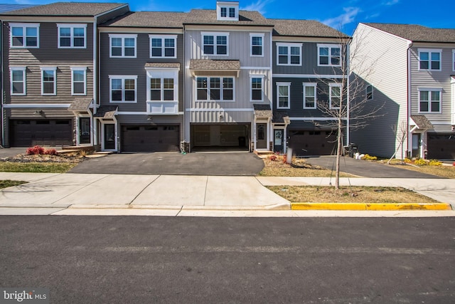 multi unit property featuring driveway, an attached garage, board and batten siding, and a residential view