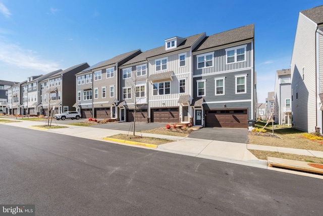 townhome / multi-family property with a residential view, an attached garage, board and batten siding, and driveway