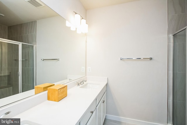 bathroom with visible vents, a stall shower, vanity, and baseboards