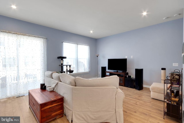 living room featuring light wood-style flooring, recessed lighting, visible vents, and baseboards