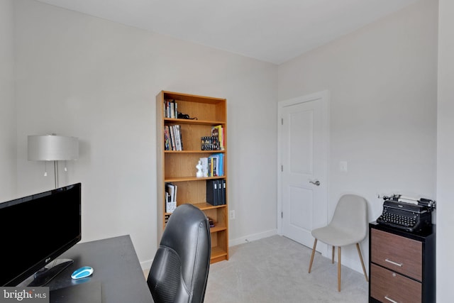 office featuring baseboards and light carpet