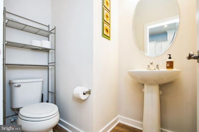 bathroom featuring baseboards, toilet, and wood finished floors