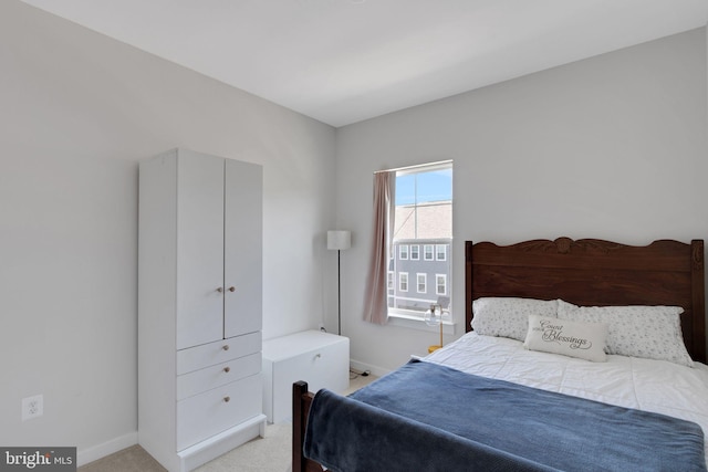 bedroom featuring light colored carpet and baseboards