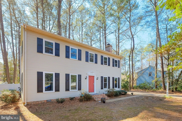 colonial home with crawl space, a chimney, and fence