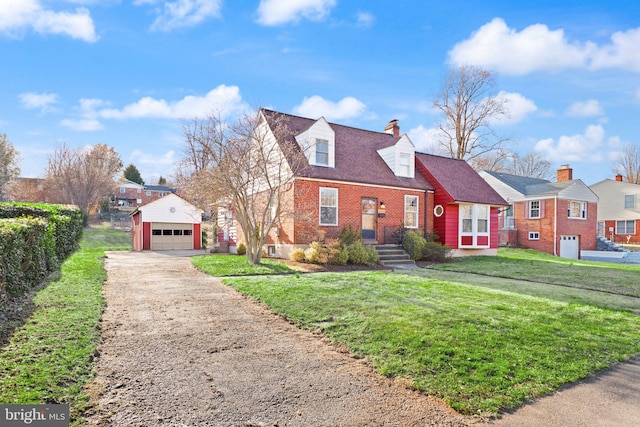 cape cod-style house featuring an outbuilding, a chimney, concrete driveway, a front lawn, and brick siding