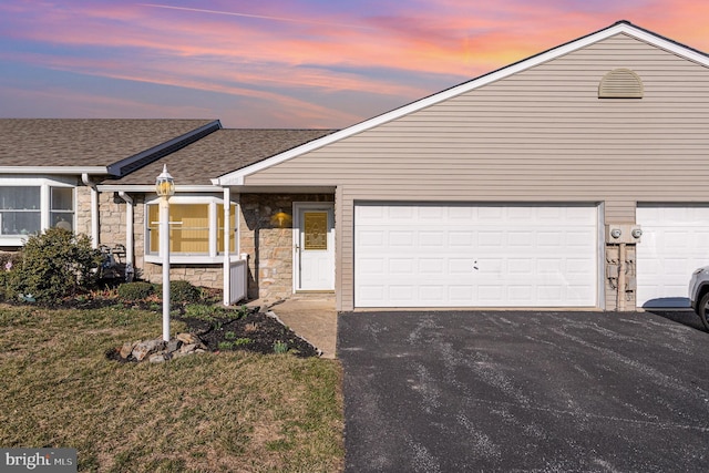 view of front of house with aphalt driveway, stone siding, and roof with shingles