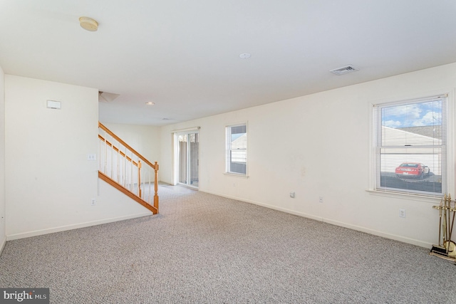 spare room featuring visible vents, baseboards, stairs, and carpet