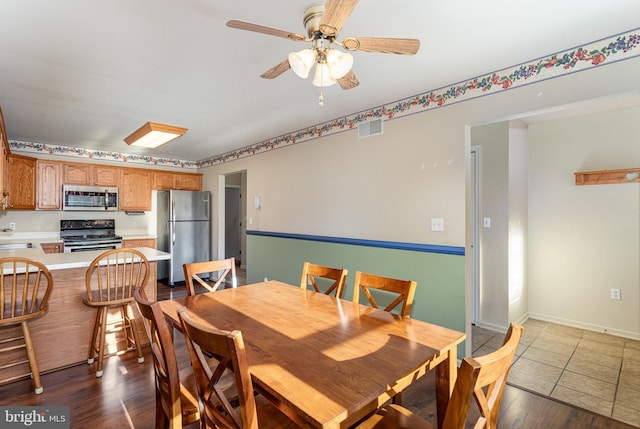 dining area featuring baseboards, wood finished floors, visible vents, and ceiling fan