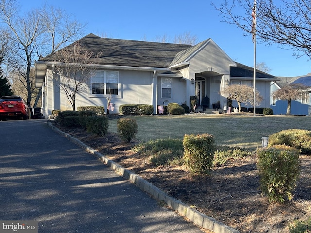 ranch-style home with stucco siding and a front yard