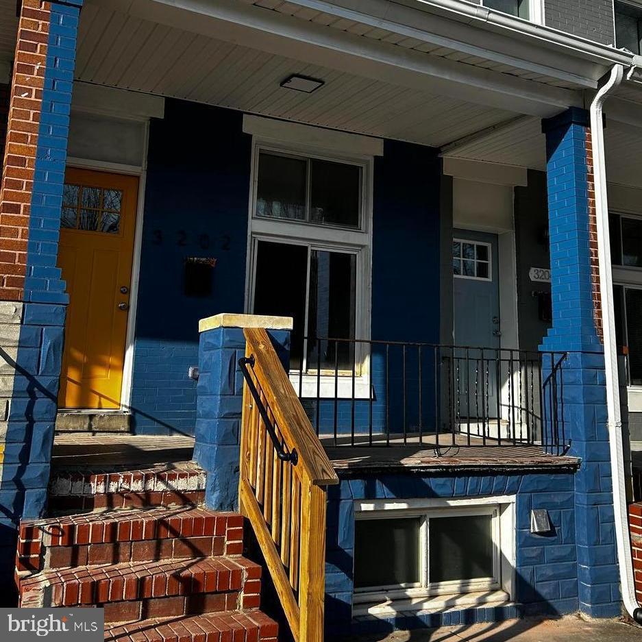 doorway to property with brick siding and a porch