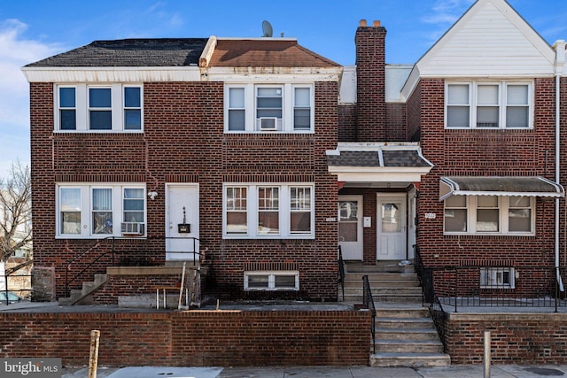 multi unit property featuring brick siding and a chimney