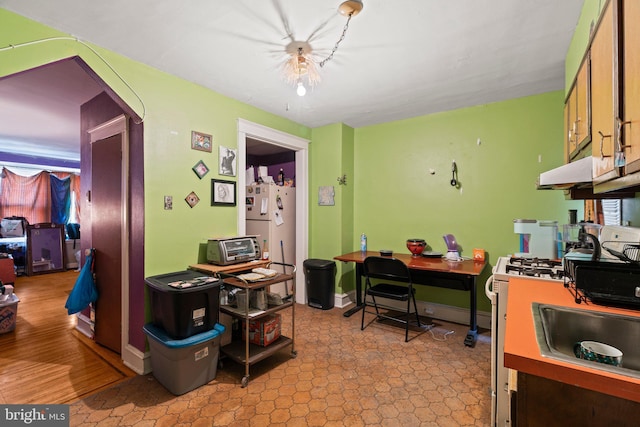 office with a toaster, baseboards, arched walkways, and a sink