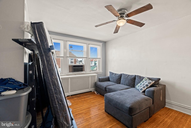 interior space with radiator, wood finished floors, baseboards, and ceiling fan