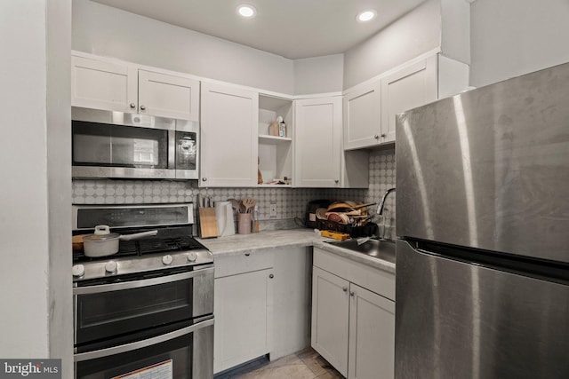 kitchen with a sink, open shelves, backsplash, stainless steel appliances, and light countertops