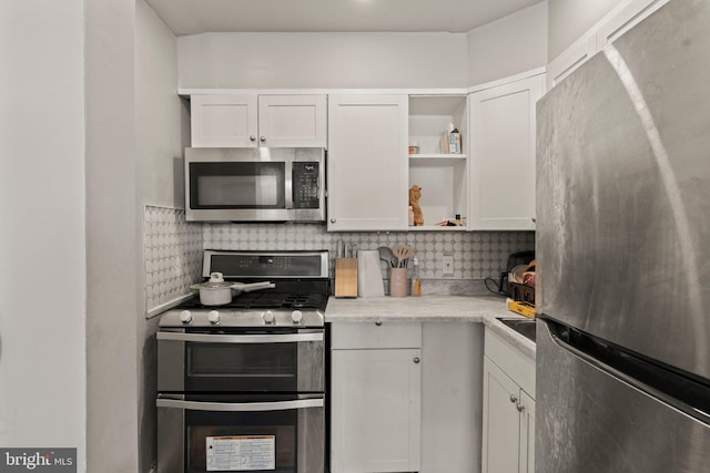 kitchen featuring tasteful backsplash, appliances with stainless steel finishes, white cabinetry, and open shelves