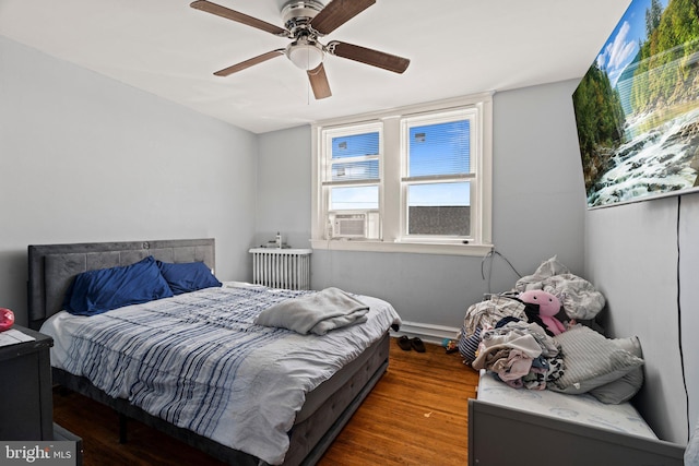 bedroom with radiator, wood finished floors, and a ceiling fan