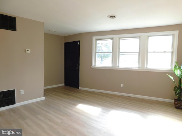 unfurnished living room with visible vents, light wood-style flooring, and baseboards