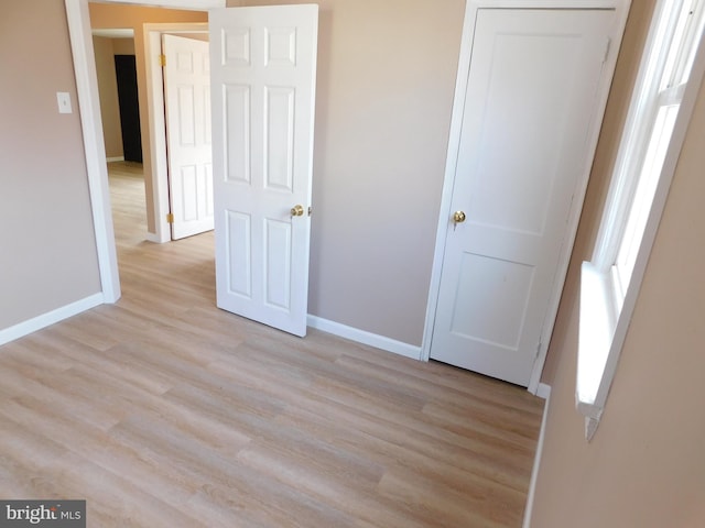 unfurnished bedroom featuring light wood-type flooring and baseboards