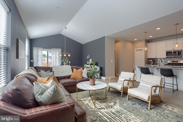 living area featuring recessed lighting, baseboards, lofted ceiling, and wood finished floors