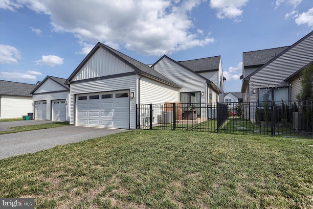 view of front facade featuring board and batten siding, fence, a front yard, a garage, and driveway