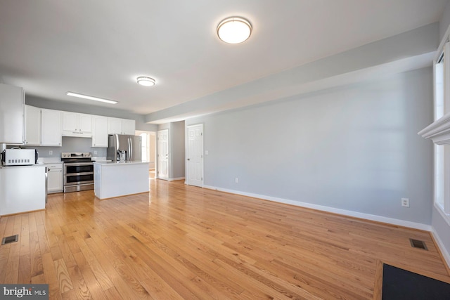 unfurnished living room featuring light wood-style flooring, baseboards, and visible vents