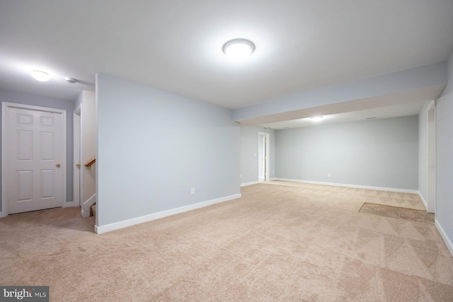 finished basement featuring stairway, baseboards, and carpet