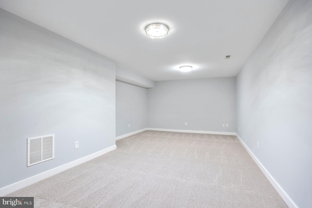 unfurnished room with light carpet, visible vents, and baseboards