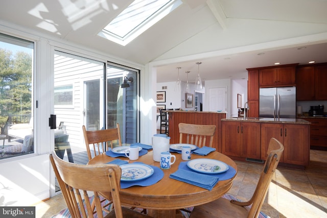 dining room with vaulted ceiling with skylight