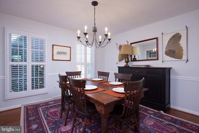 dining space with wood finished floors, baseboards, and a chandelier