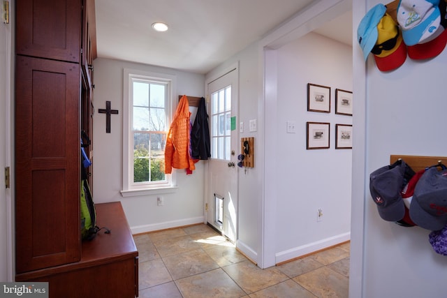 foyer featuring light tile patterned flooring and baseboards