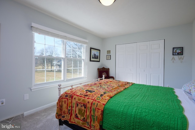 bedroom featuring a closet, visible vents, carpet flooring, and baseboards