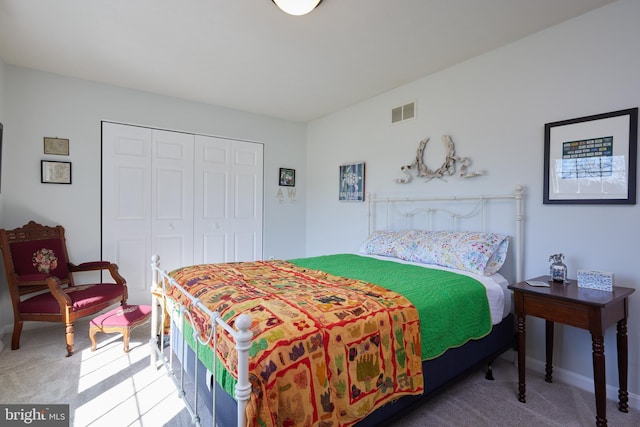 carpeted bedroom featuring visible vents and a closet