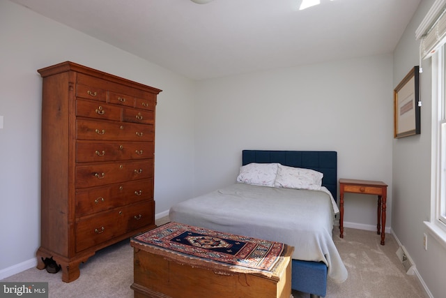 bedroom featuring visible vents, light colored carpet, and baseboards