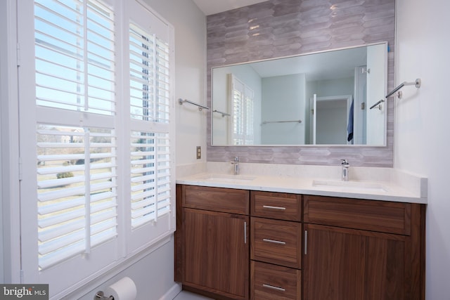 full bathroom featuring double vanity, tasteful backsplash, and a sink