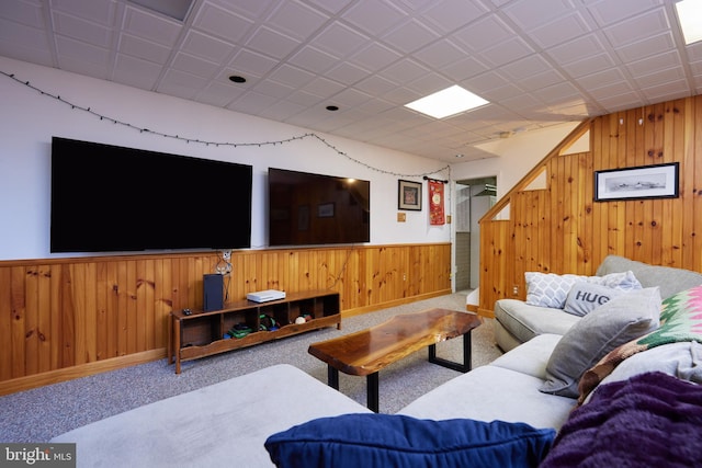 living room with carpet floors, wood walls, and wainscoting