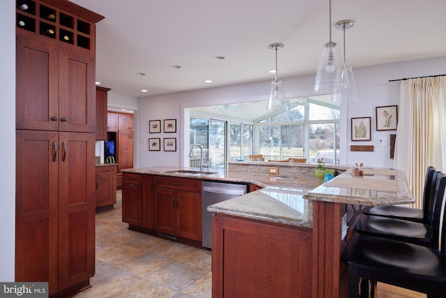 kitchen with a sink, decorative light fixtures, recessed lighting, a breakfast bar area, and dishwasher