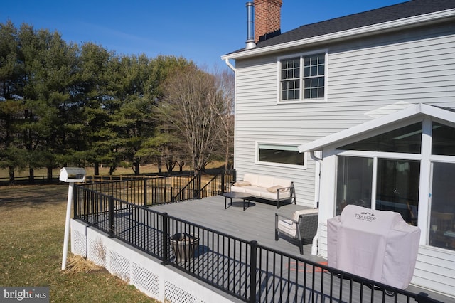 wooden terrace with an outdoor living space, area for grilling, a lawn, and a sunroom