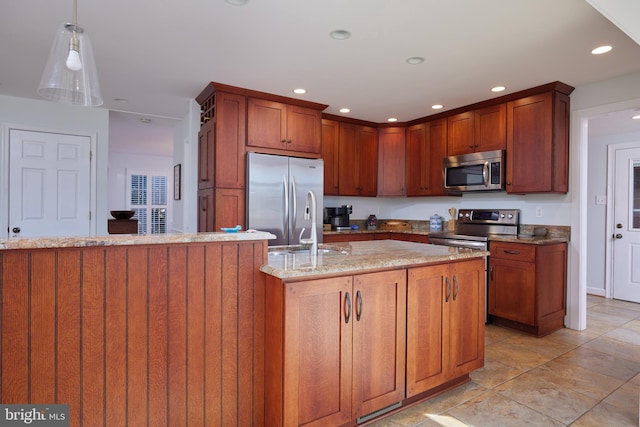 kitchen with light stone countertops, recessed lighting, appliances with stainless steel finishes, hanging light fixtures, and a sink