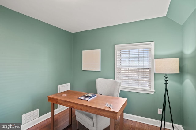 office space with wood finished floors, baseboards, visible vents, and lofted ceiling