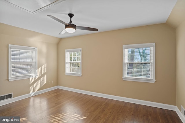 unfurnished room with visible vents, baseboards, lofted ceiling, wood finished floors, and a ceiling fan