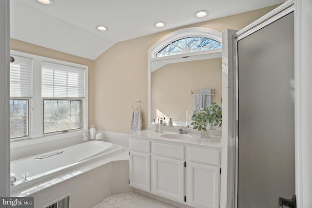 full bath with visible vents, a garden tub, a shower stall, vanity, and vaulted ceiling