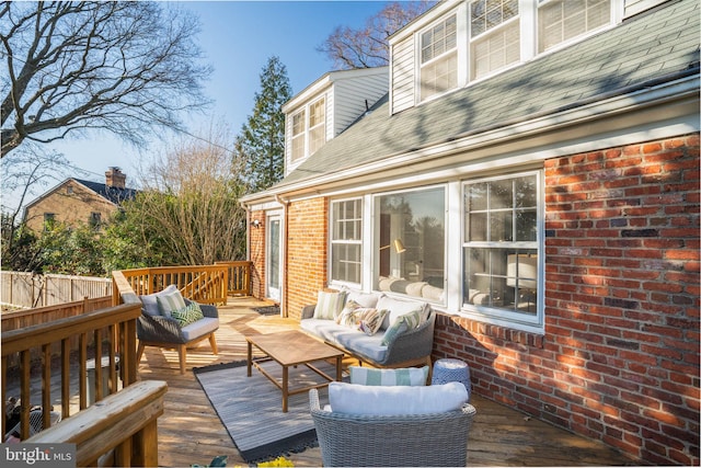 wooden terrace with an outdoor living space and fence