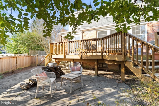 view of patio featuring stairway, fence, and a wooden deck