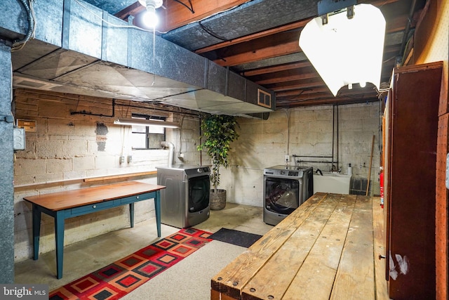 unfinished below grade area with a sink, visible vents, a wood stove, and washer and clothes dryer