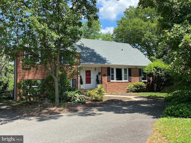 view of front facade with brick siding and fence