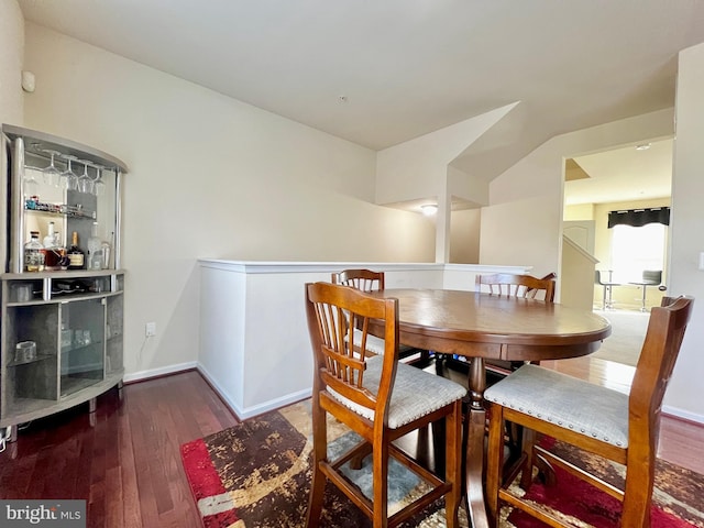 dining space with baseboards and wood-type flooring