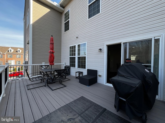 wooden deck featuring outdoor dining area and a grill