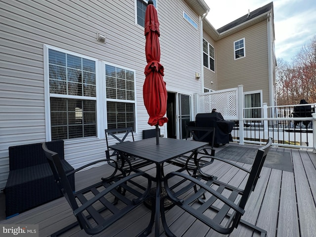 deck with outdoor dining area and grilling area