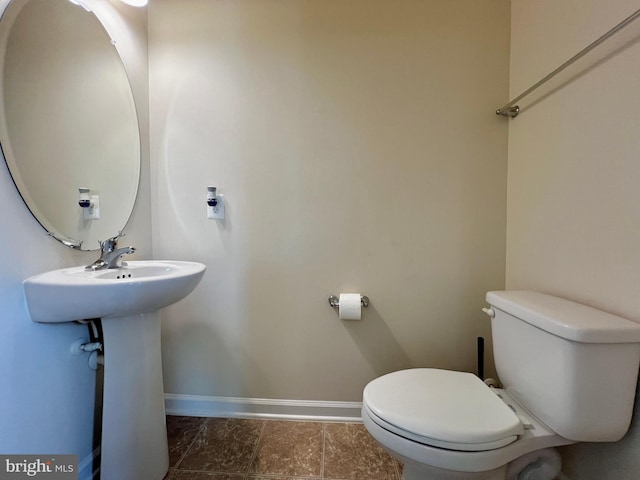 bathroom with baseboards and toilet